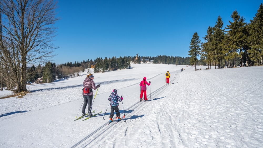 A family cross country skiing in New York in Lake George on a sunny winter day