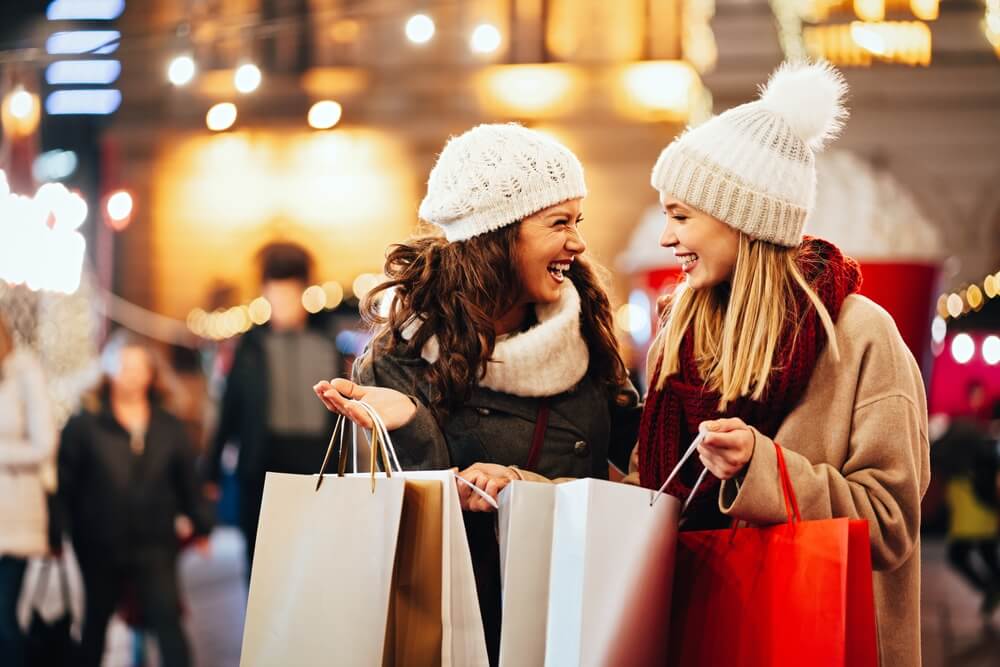 Two women with shopping bags exploring the Lake George outlets during the holidays