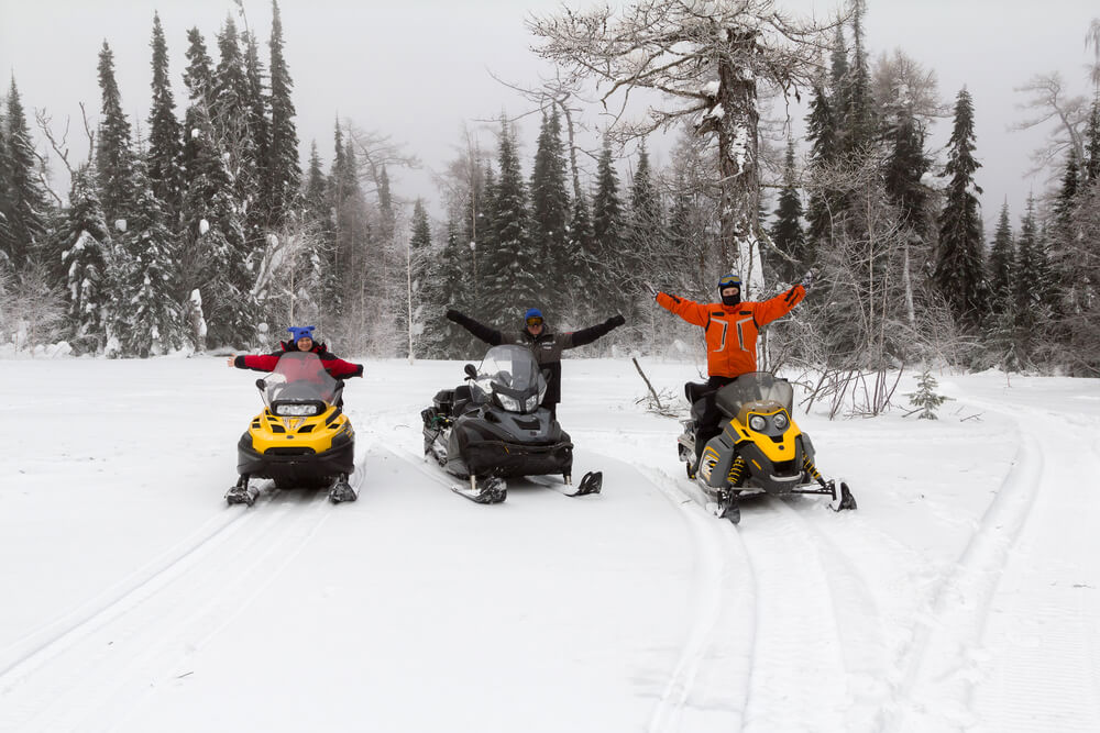 People snowmobiling along Lake George winter trails